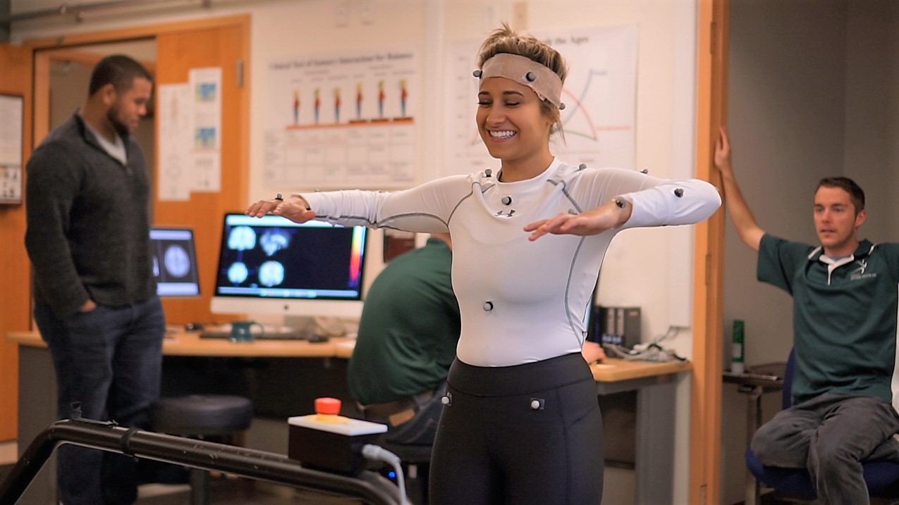 A woman goes through her range of motion while wearing body monitors.