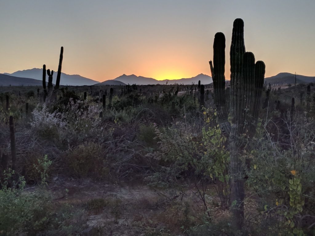 The sun setting over mountains and the desert.