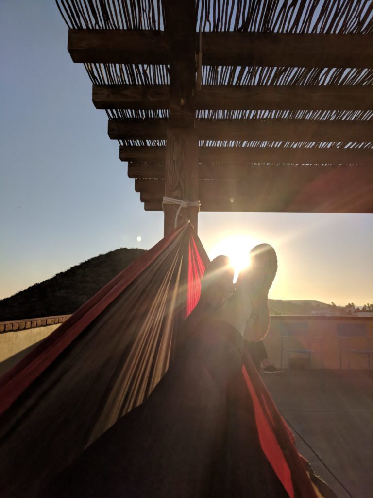 Student resting in hammock watching the sun rise