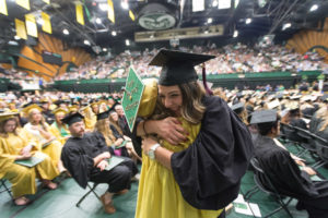 students hugging at graduation