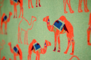 Green fabric with orange camel print