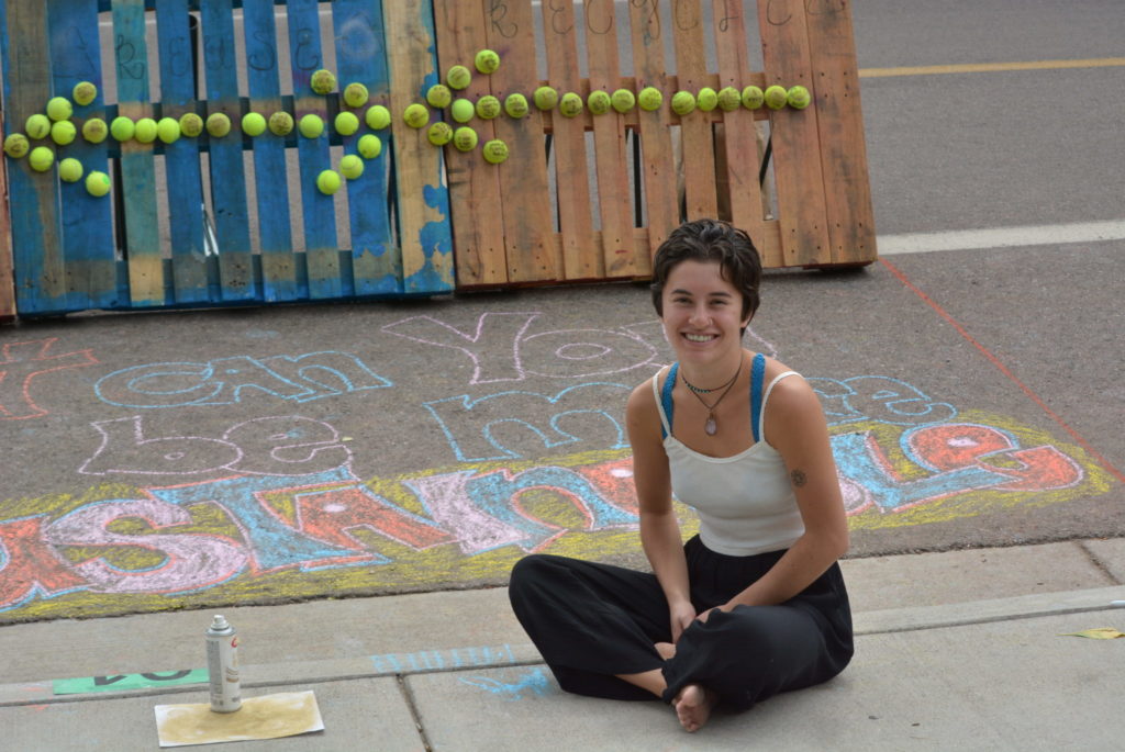 Student sitting with chalk mural