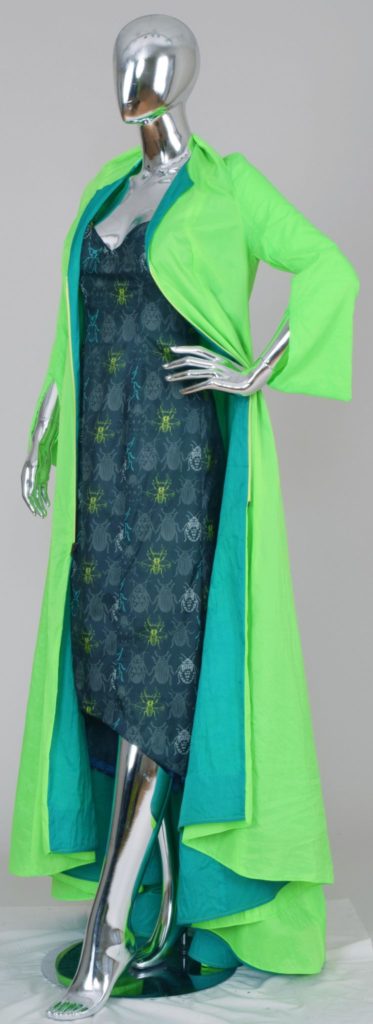 This slender evening gown is decorated with multi-hued insects in greens and teals. The bright green coat completes the ensemble.