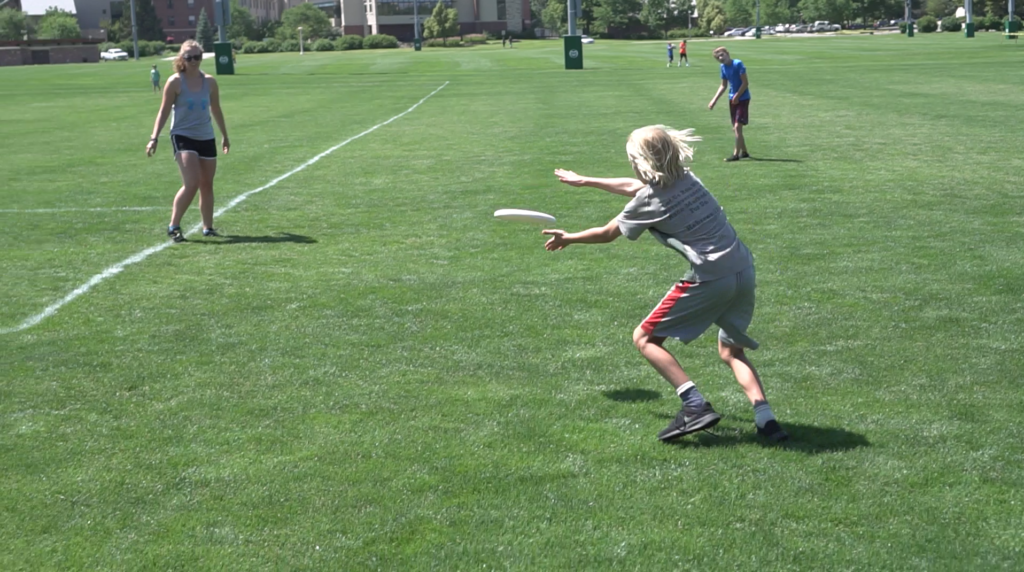 A boy catches a frisbee on a field