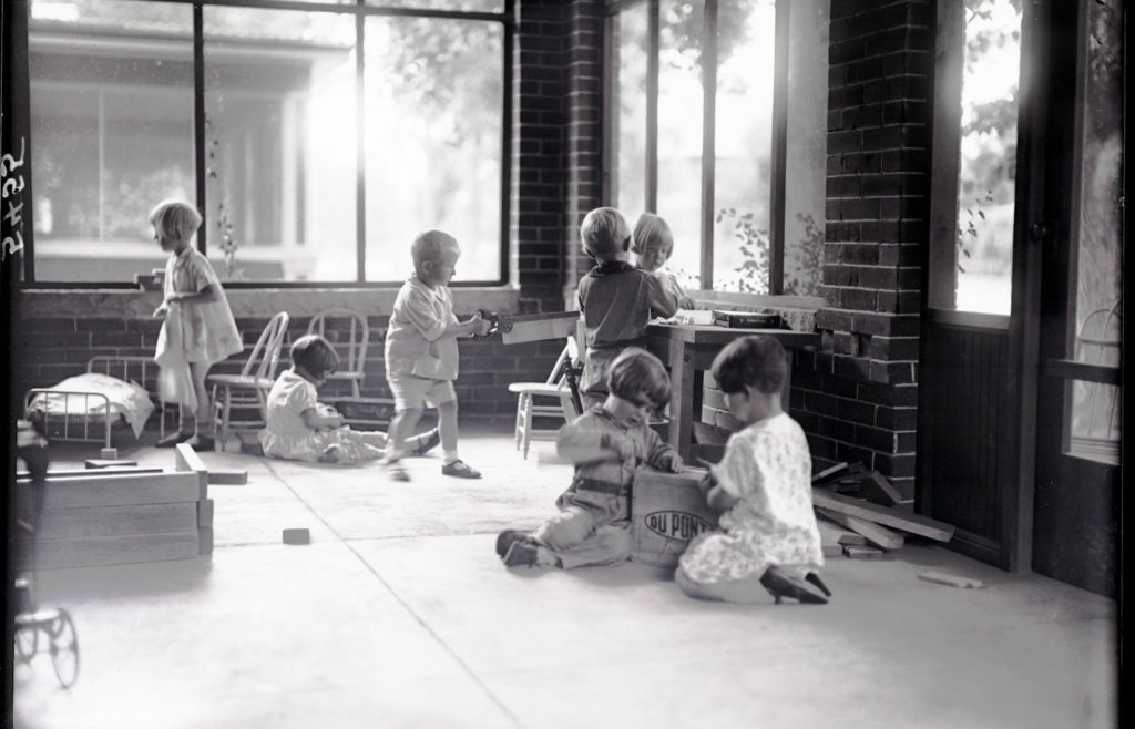 Children playing on the Laurel St. house porch