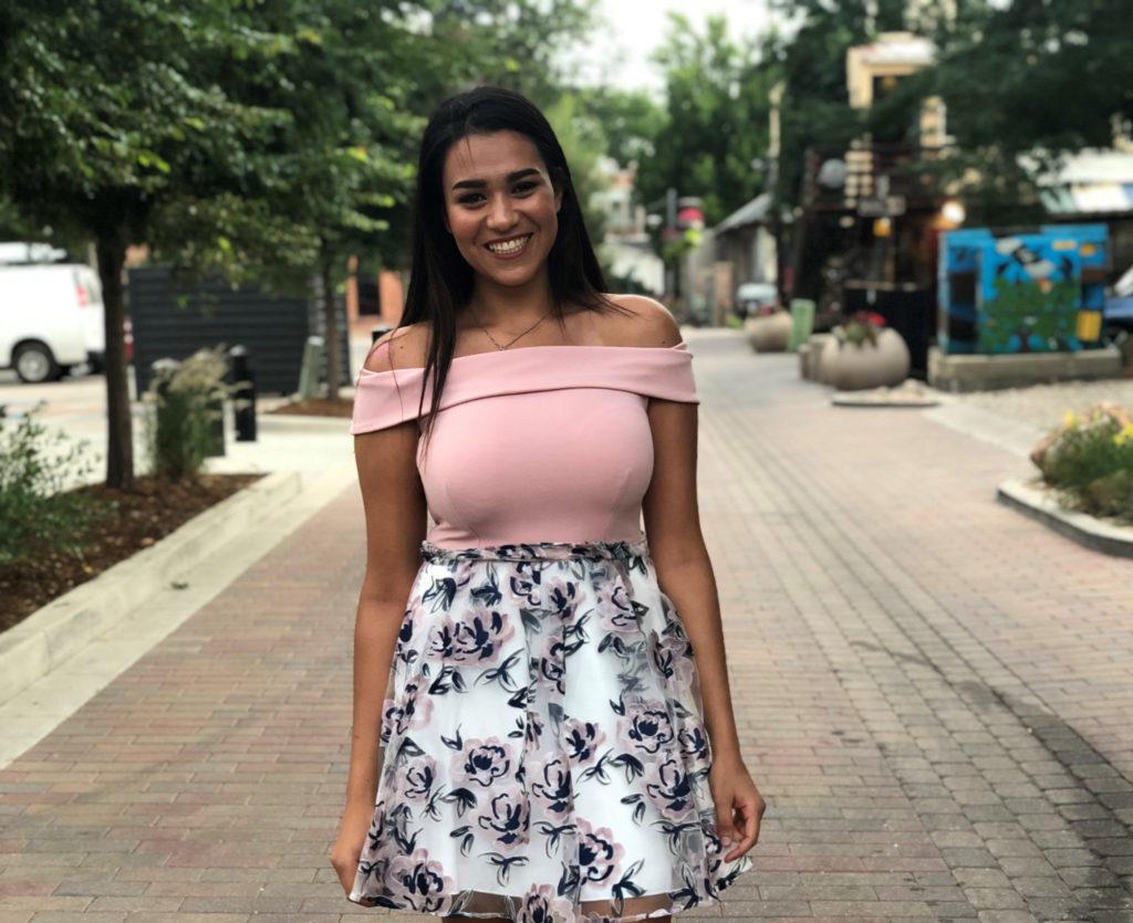 KRNC Student Stoplight recipient Nancy Ghanem on a sunny day in a pink top and floral skirt. 