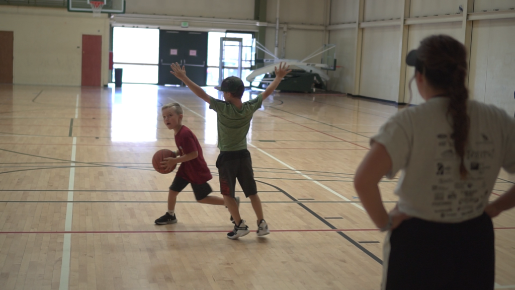 Two boys playing basketball in the gym