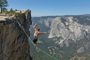 Dakota Collins walking tightrope across a mountain canyon