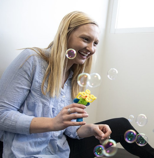 woman plays with a bubble blower