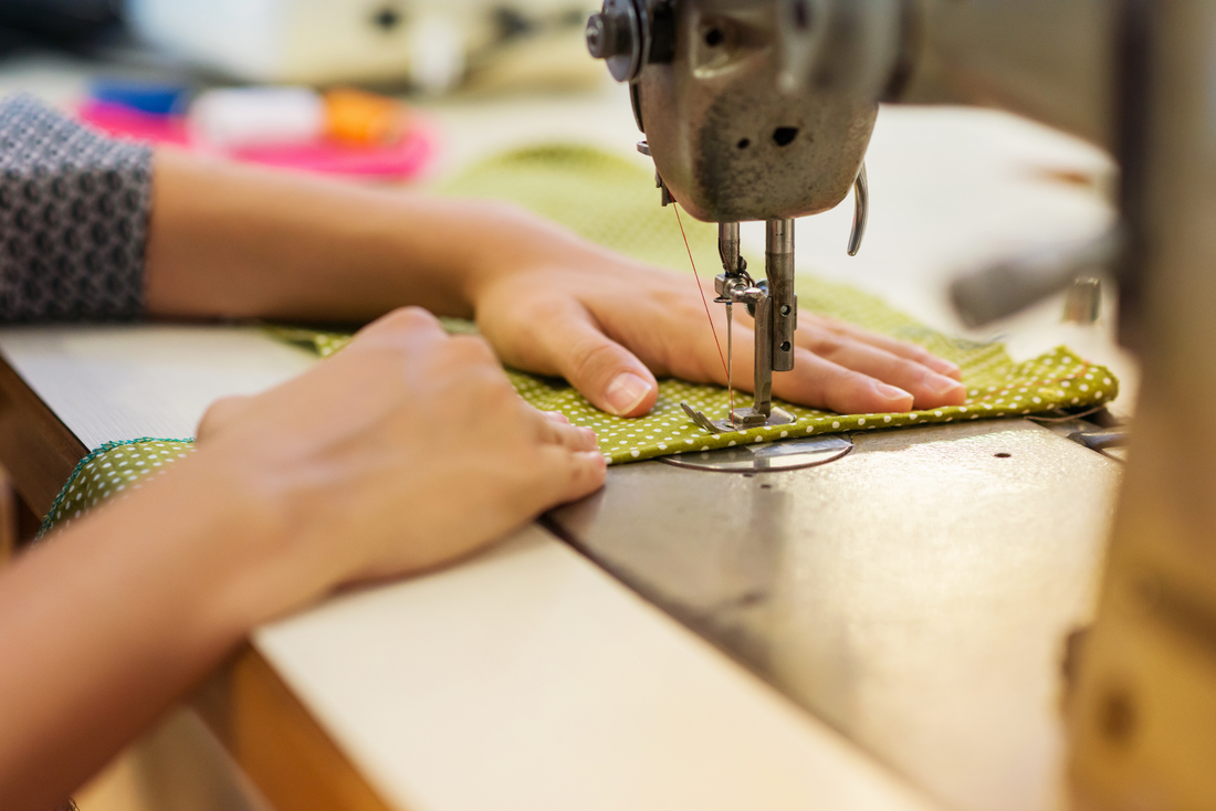 woman sews fabric on machine