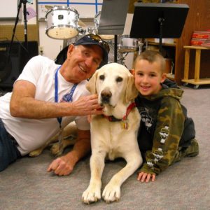 habic volunteer wayne boyles and his therapy dog rex with a student