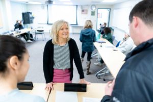 Assistant professor Dawn Mallette smiles while engaging with students in a classroom.