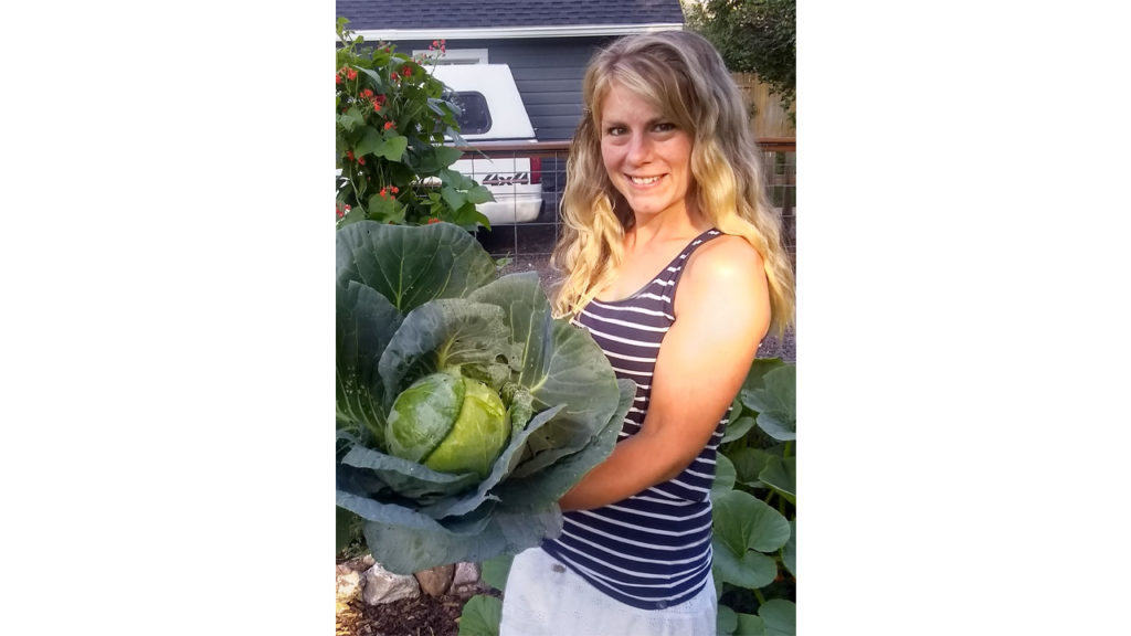 Jenny Whittington holds a large head of lettuce.