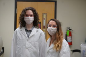 Brayden Smith and Lauren Grabos in lab coats and masks