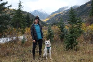 Kalena Giessler Gonzalez with her dog with fall color and mountains in the background