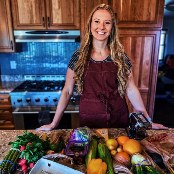 Jenica Sounart in a kitchen with several different types of produce
