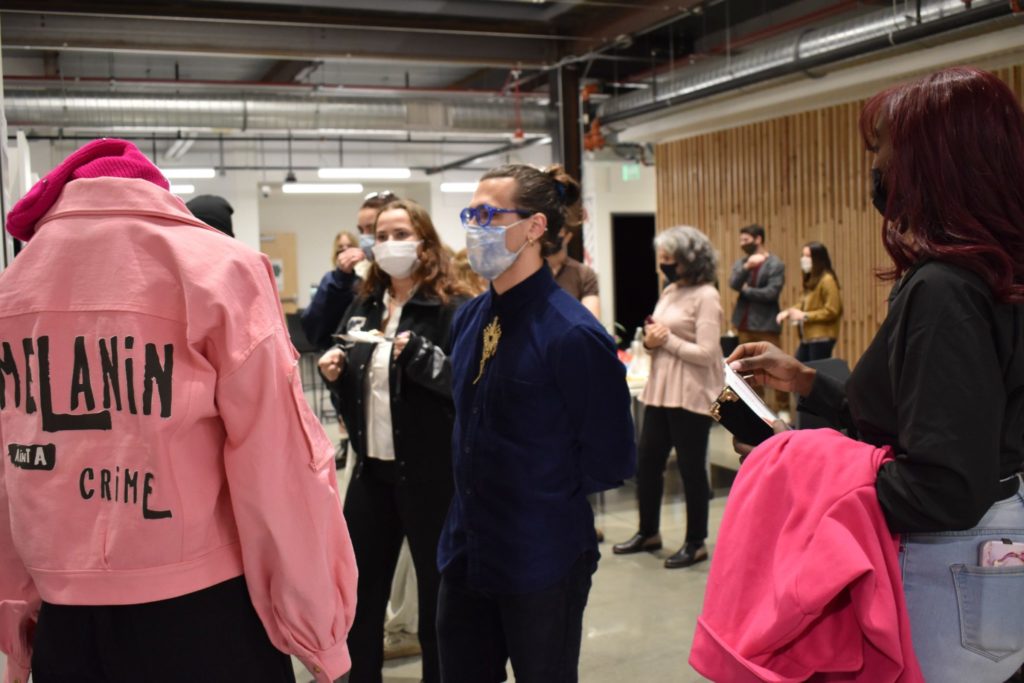 Reception attendees admire Quatia Thompson's prototyped jacket