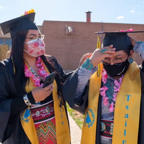 Two graduates from Dine College in their graduation garb