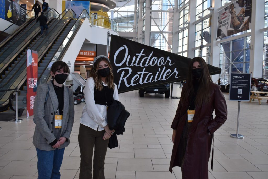 Students pose in front of the Outdoor Retailer sign
