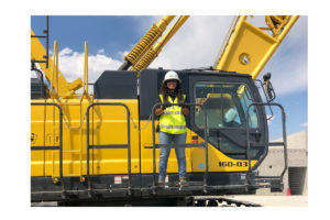 Erin Dominguez in hard hat on large equipment