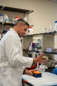 Chris Gentile pipetting at a bench in his lab