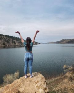 Shelby Archuleta standing at horsetooth with her arms up