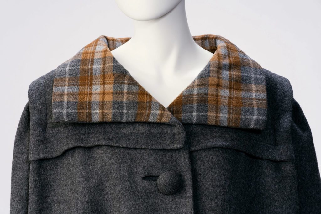Detail of grey coat with plaid lining.