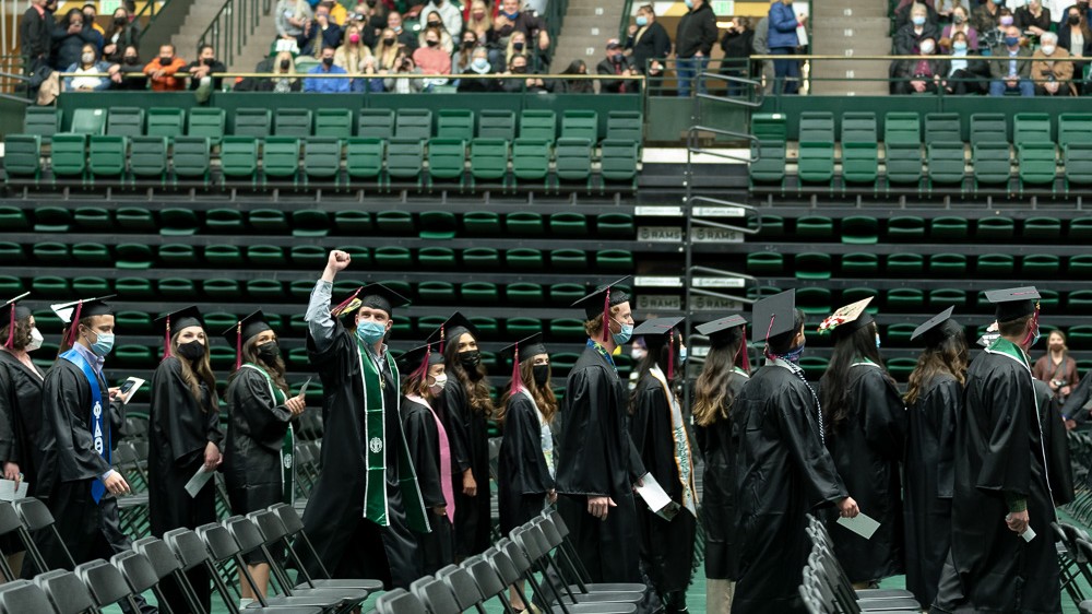 Students in graduation attire celebrate in the Moby Arena
