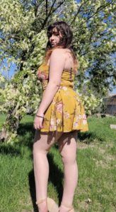 Outdoor portrait of Sarah Fizer wearing a yellow sun dress