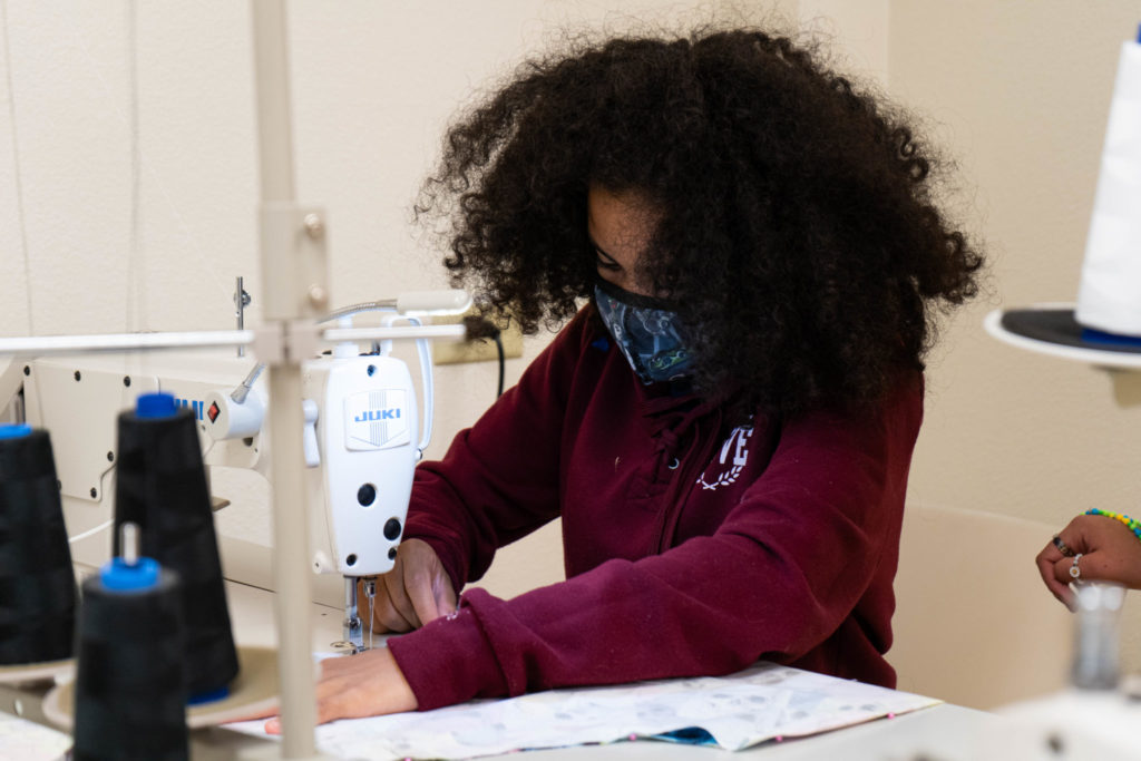 A student uses a sewing machine.