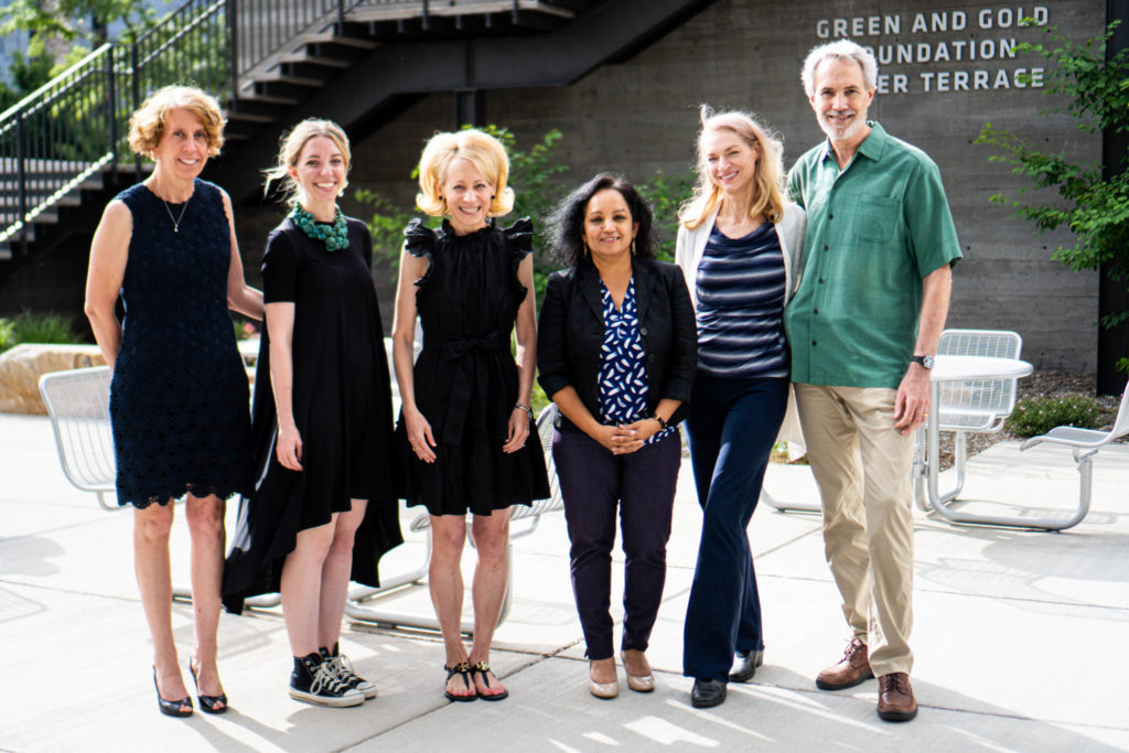A group of Fashion FUNdamentals coordinators and donors smile for a photo outside of the Nancy Richardson Design Center.