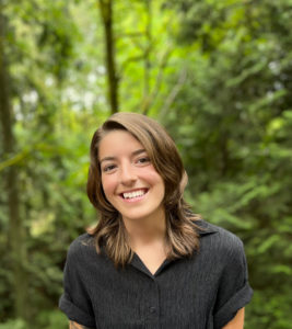 Portrait of Emily Tull smiling while standing in the forest