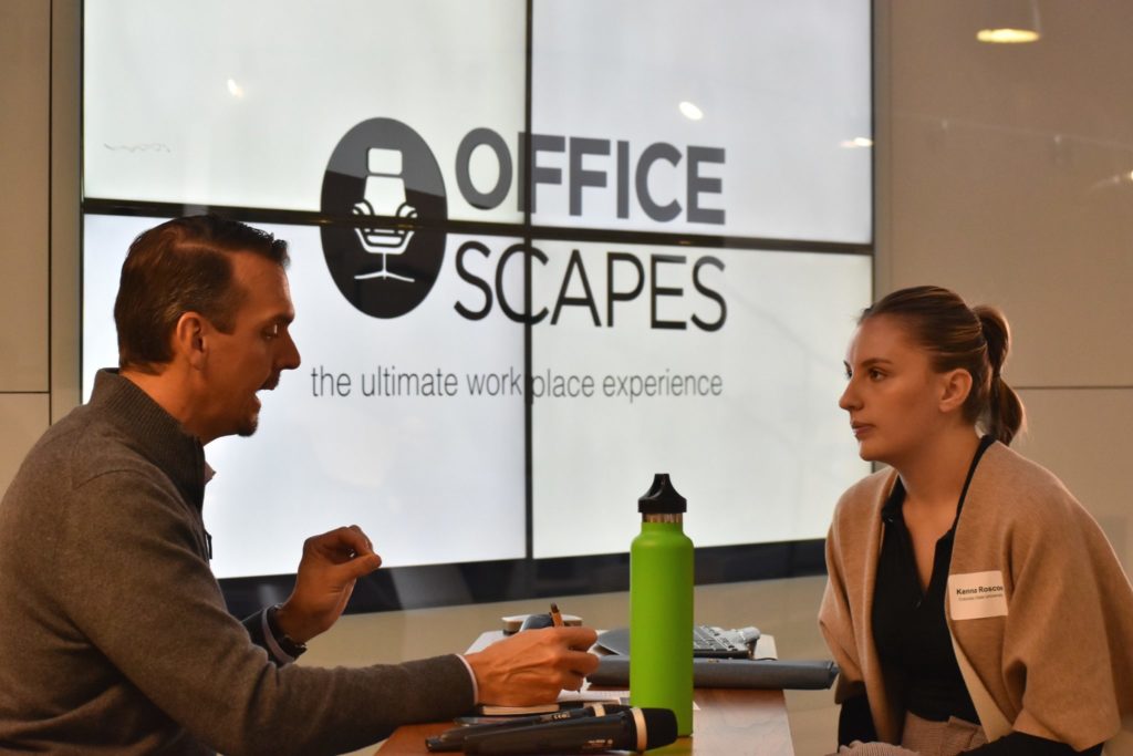 A student particpates in an interview in front of the Office Scapes logo.