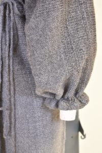 Detail of the woven sleeve tightened to gather at the wrist in a design by Katie Miller