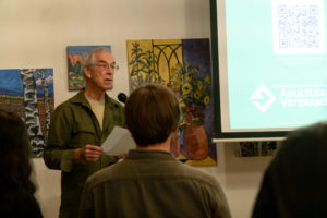 A workshop participant reads his writing to the audience.