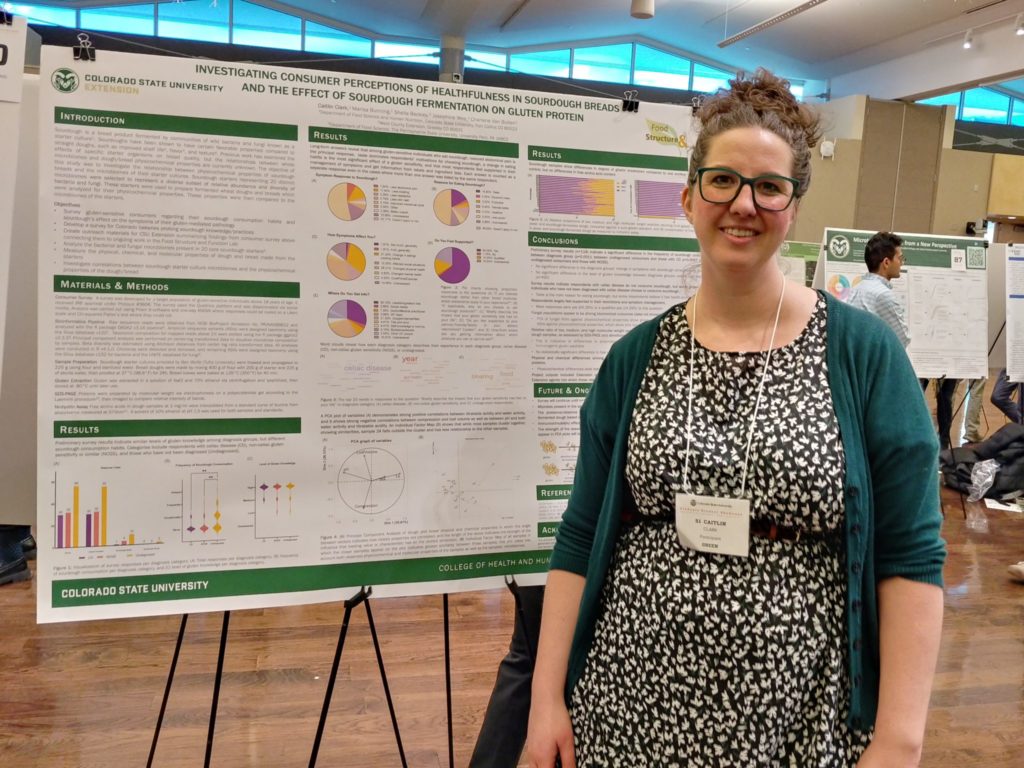 Caitlin Clark smiles next to her research poster.