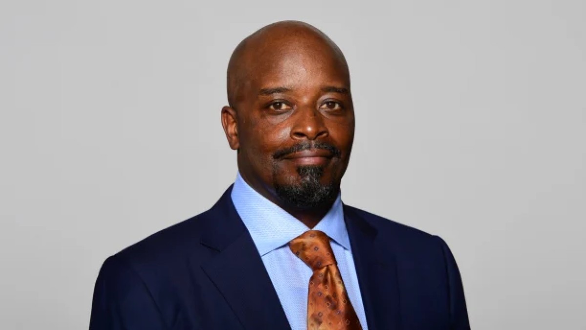 Headshot an African-American man in a suit with a blue shirt and orange tie