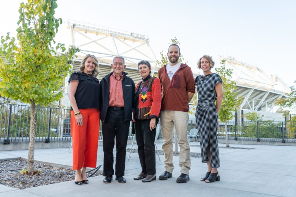 Alli Haltom, Jerry Culp, Antigone Kotsiopulos, Nelson English, and Karen Hyllegard pose for a photo in front of the stadium after the panel discussion.