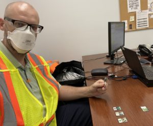 Seth Yoder sits at a desk wearing a mask