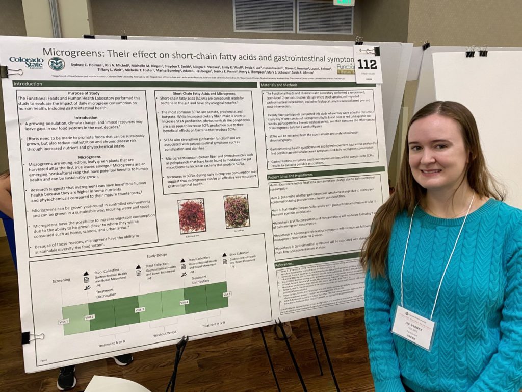 Sydney Holmes next to her research poster.
