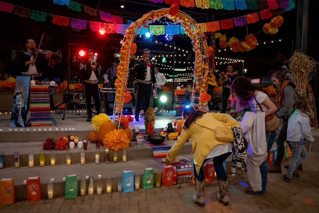 A Day of the Dead event stage with candles and musicians