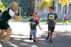 CAM the Ram high-fives a child while another child looks on