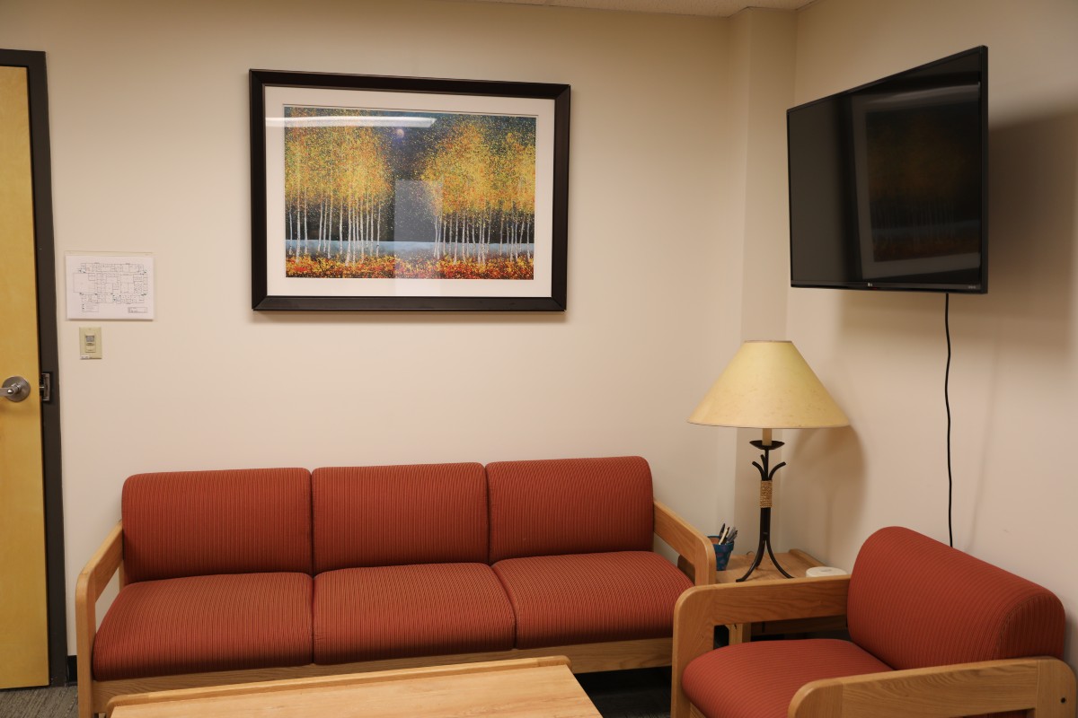 A therapy waiting room with rust-colored sofa and chair