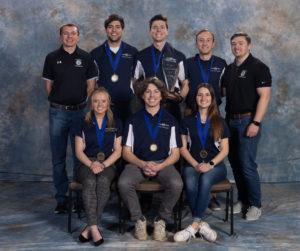 CM Mixed Use team of 6 male student members and 2 females student members. Male captain of team holding trophy, middle back.