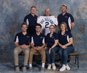 CM Preconstruction team with male faculty coach, center back holding jersey that says second; 4 student male members and 2 student female members