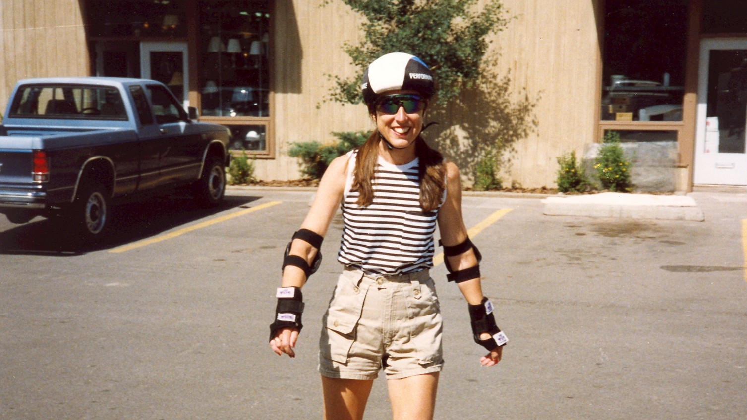 A woman rollerblades in a parking lot.