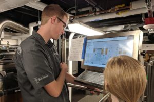 Two engineers assess a brewery control system at a monitor