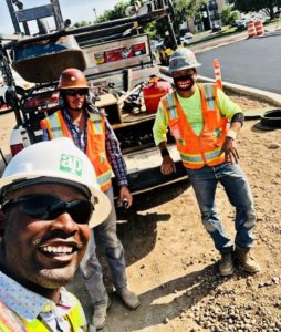 CM student Joseph Begue in selfie with coworkers on jobsite, 3 people in hard hats