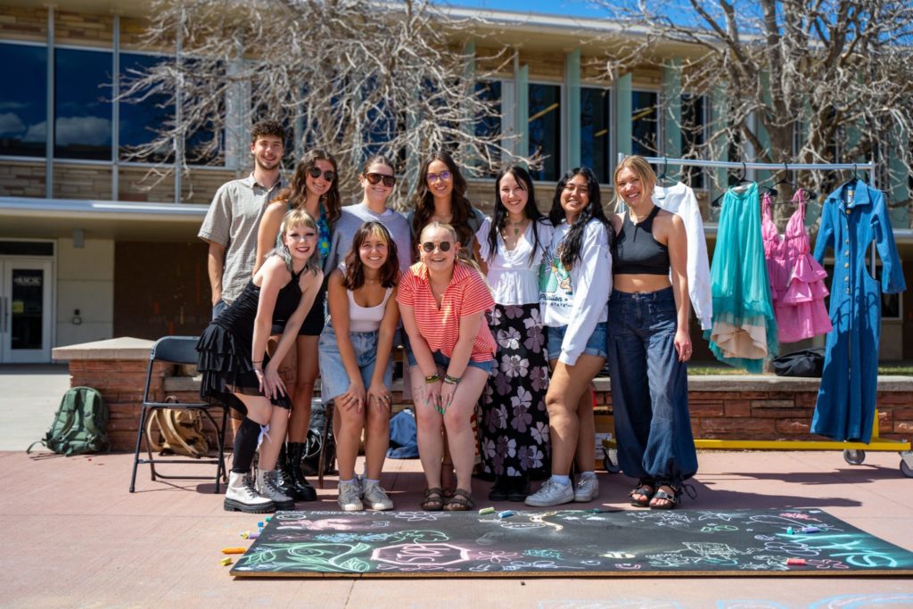 students from the fashion show planning class pose together at a promotion event on the student center plaza