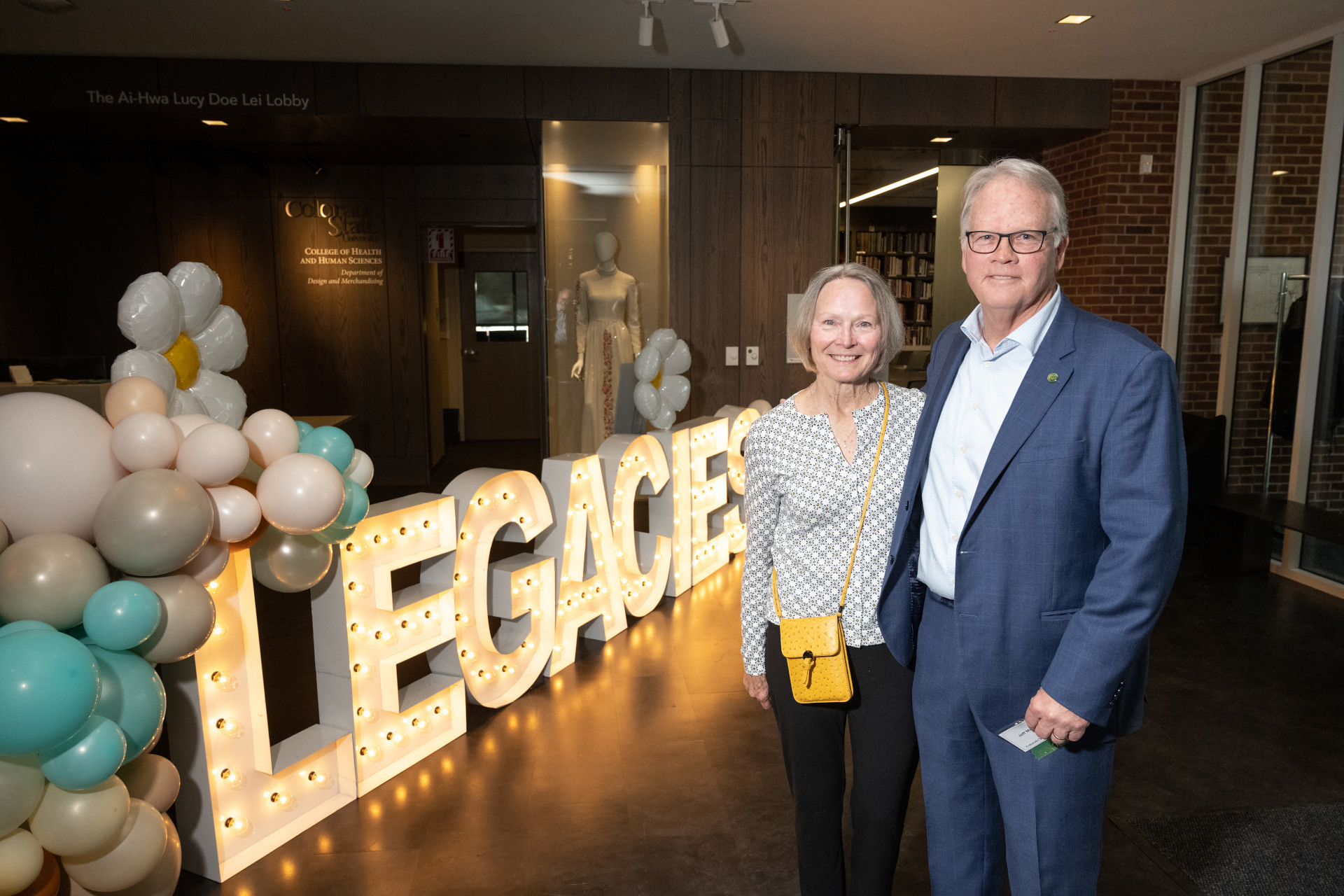 Jeff and Debbie McCubbin stand in front of the lighted Legacies sign
